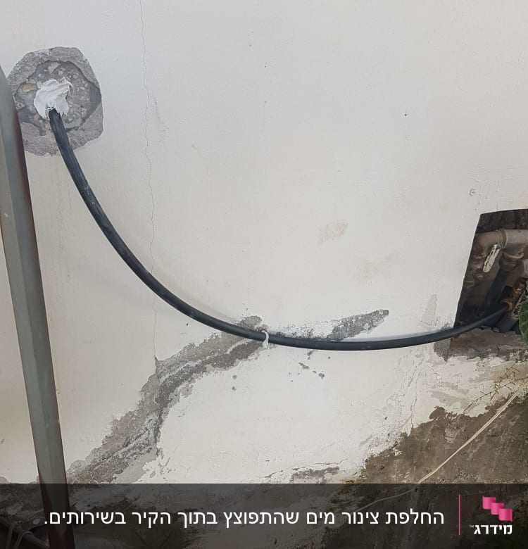 צינור שחור מחובר לקיר עם חיבורי מתכת